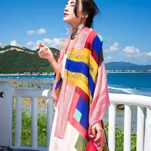 Detailed view of colorful geometric striped cotton linen beach scarf shawl seaside vacation wear.