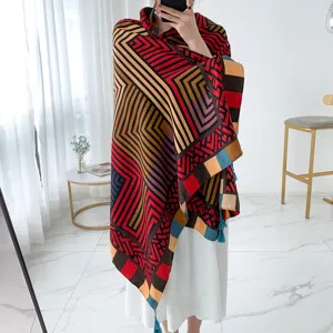 Detailed view of a vibrant geometric printed shawl with fringe, perfect for beach and travel.