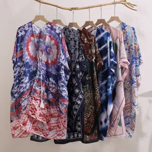 Detail view of colorful printed kimono cardigans hanging, summer bohemian beach cover up styles