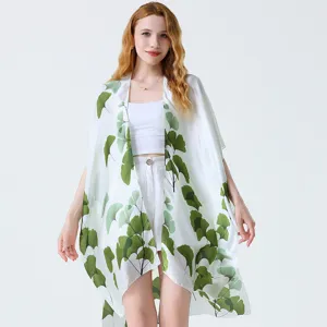Vista dettagliata del motivo con foglie di ginkgo verde sul cardigan kimono estivo.