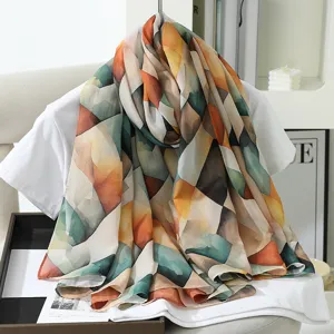 Close-up detail of geometric print imitation silk scarf, highlighting soft texture and colors.