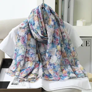 Detailed view of the vibrant watercolor floral print scarf draped gracefully on a chair.