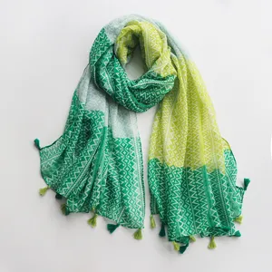 Detail de foulard imprime style ethnique, echarpe en coton et lin vert jaune avec franges.