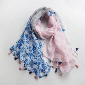 Vue détaillée d'une écharpe imprimée légère avec motifs floraux et délicats glands pour femmes.