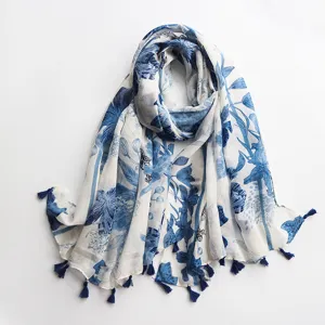 Vue rapprochée du foulard à fleurs bleu et blanc avec franges délicates et tissu doux.