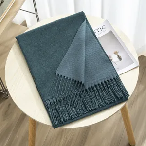 Detailed view of a thick double-sided solid color cashmere-feel tassel winter scarf.