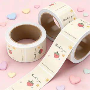 Detailed close-up shot of thank you sticker roll with cute strawberry design for gift packaging.