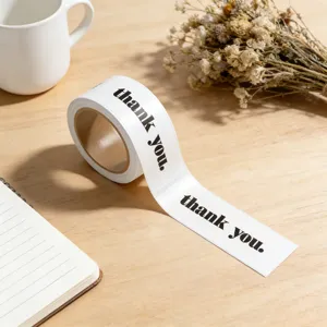 Close-up of minimalist rectangular thank you sticker roll with elegant black typography.