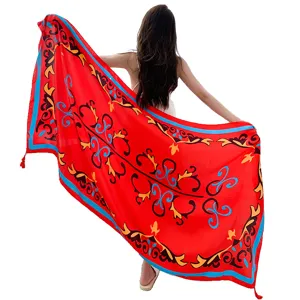 Detailed view of the ethnic style red beach scarf, featuring vibrant scrolls and tassels.