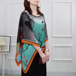Detail view of the artistic floral and crane print on the elegant women's cape top.
