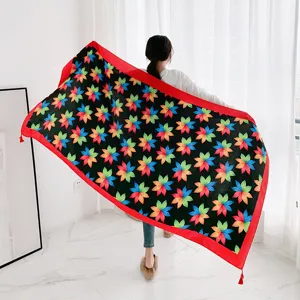 Detail view of a retro ethnic floral print shawl with red tassel border and soft fabric material.