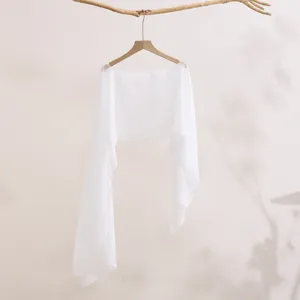 Detailed view of white summer sun protection lightweight shawl long sleeve cover-up top.