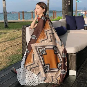 Outdoor resort detail shot of a retro ethnic print women's shawl scarf draped on a sofa.