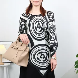 Close-up detail of black and white floral pattern silk cape shawl for elegant summer wear.