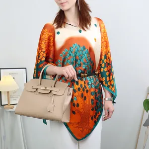 Detail view of the elegant imitation silk sun protection cape featuring vibrant tree leaf print.