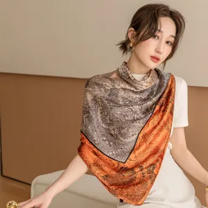 Elegant women's square silk scarf featuring a chic black, white and orange printed design.
