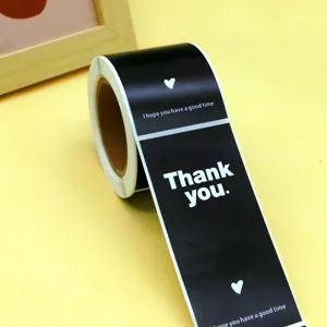 Détail d'un rouleau d'autocollants de remerciement noirs avec texte blanc et beau cœur.