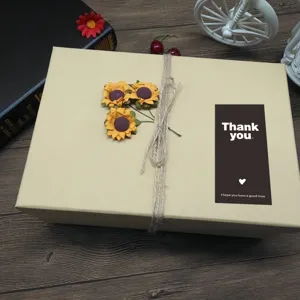 Boîte cadeau beige décorée de tournesols en ficelle et d'un autocollant de remerciement.
