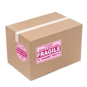 Detail view of fragile warning sticker on shipping box, pink waterproof label with care text.