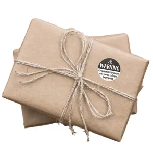 Autocollant d'avertissement décoratif sur boîte-cadeau emballée avec de la ficelle.