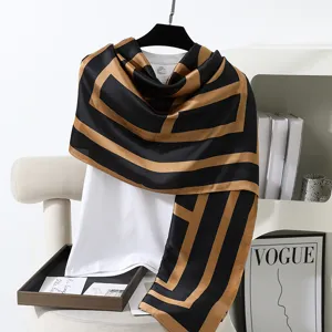 Elegante sciarpa lunga in seta geometrica nera e oro da donna, ideale per la protezione solare.