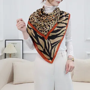 Elegant women's square scarf featuring chic leopard and zebra print with vibrant orange border.