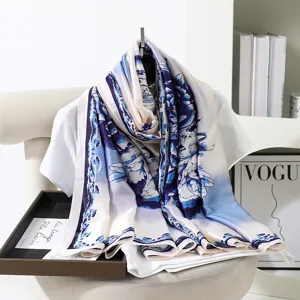 Dettaglio in primo piano del foulard in seta vintage blu e bianco con elegante motivo floreale.