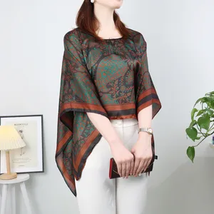 Detailed view of women's paisley silk-like poncho shawl, loose summer sun protection cape top.