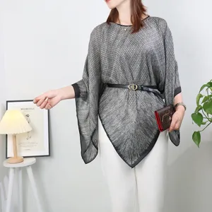Detailed view of the stylish imitation silk poncho shawl worn with belt and matching clutch.