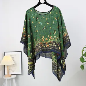 Green silk-like poncho cape featuring elegant botanical bird print and chic border hem design.