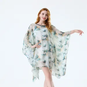 Gros-plan détaillé de la robe de plage transparente à motif de feuilles et tissu léger.