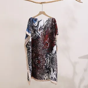 Detail view of a women's abstract print sunscreen shawl, loose off-shoulder summer top.