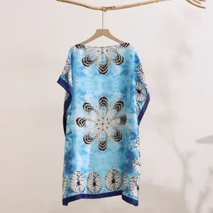 Detailed view of blue tie-dye print beach cover-up shawl, elegant floral abstract pattern fabric