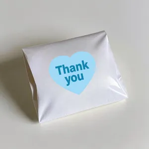 White paper packaging bag with cute blue heart Thank you sticker, delicate detail view item.