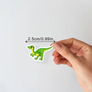 Close-up detail of the cute cartoon dinosaur waterproof sticker displaying its compact size.