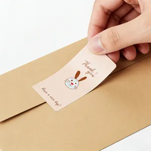 Close-up detail shot of a cute thank you sticker with bunny illustration on envelope.