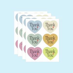 Heart-shaped macaron color thank you sealing stickers, detailed view of stacked sheets.