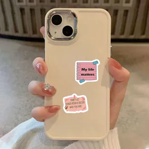 Close-up detail of beige phone case with inspiring pink sticky note sticker design.