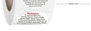 Detailed close up view of round candle warning sticker roll with English safety instructions.