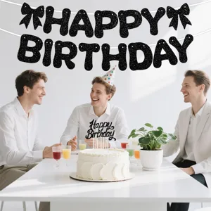 Close-up details of black glitter happy birthday banner and cake topper for party decor.