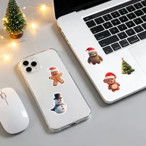 Vista dettagliata di simpatici adesivi natalizi con animali su laptop e telefono, fai da te.