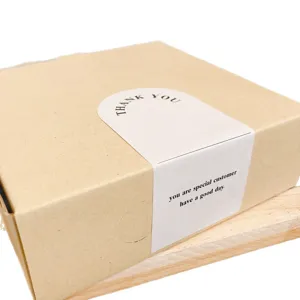 Kraft paper gift box with elegant white sealing sticker featuring custom text for packaging.