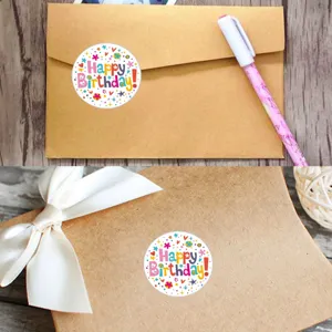 Vue detaillee d'autocollants d'anniversaire ronds et colores sur des boites en papier kraft.