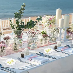 Clear acrylic place cards detail scene on beach wedding table setup with floral decor