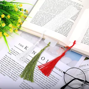Marcadores de libros de acrílico transparente con borlas de colores en un libro.