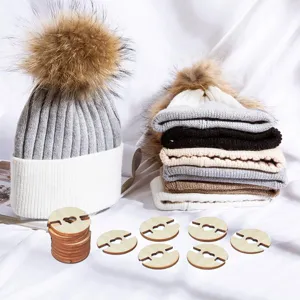 Detailed view of winter knit beanie hat with faux fur pom pom and wooden button fasteners.