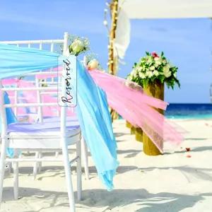 Letrero acrílico transparente para silla de boda reservado con cintas para decoración de eventos.