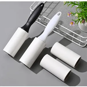 Detail view of portable lint roller set with black and white handles and two refill rolls.