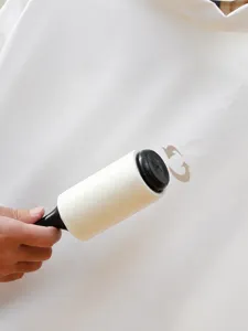 Portable lint roller detail showing 360 degree rotating axis for easy one-handed clothes cleaning.