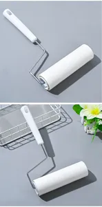 Detail view of sticky lint roller for pet hair removal with white handle and refillable core.